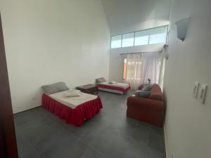 a living room with two beds and a couch at VILLA CON Piscina en Juan Dolio in La Guáyiga