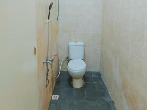 een badkamer met een toilet in een douchecabine bij De Luck Homestay near Alun Alun Sidoarjo Mitra RedDoorz in Sidoarjo