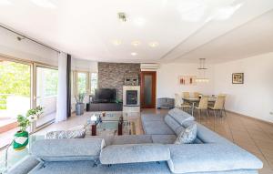 ein Wohnzimmer mit einem blauen Sofa und einem Tisch in der Unterkunft Luksuzna villa sa privatnim unutarnjim bazenom Villa Garden in Podstrana