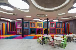 a brightly colored cafeteria with tables and chairs at Apartma PeMaks, Terme Olimia in Podčetrtek