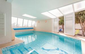 uma grande piscina num quarto com janelas em Luksuzna villa sa privatnim unutarnjim bazenom Villa Garden em Podstrana