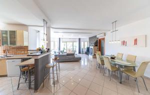 uma cozinha e sala de estar com mesa e cadeiras em Luksuzna villa sa privatnim unutarnjim bazenom Villa Garden em Podstrana