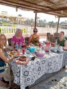un grupo de mujeres sentadas en una mesa en Seror Guest House en El Cairo