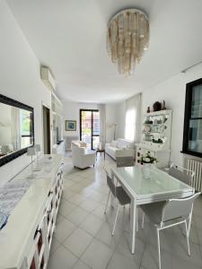 una cucina e un soggiorno con tavolo e sedie di Villetta Trieste-Flexrent Abissinia a Riccione