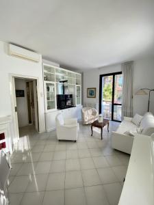 a large living room with white furniture and a tv at Villetta Trieste-Flexrent Abissinia in Riccione