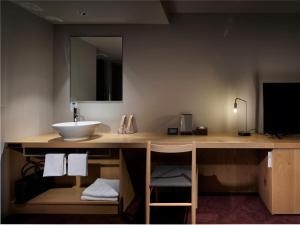 a bathroom with a counter with a sink and a mirror at hotel androoms Sapporo Susukino in Sapporo