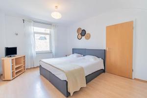 1 dormitorio con 1 cama grande y TV en Hôtel Le Petit Poète, en Echternach