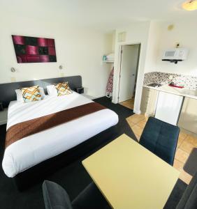 ein Hotelzimmer mit einem großen Bett und einem Tisch in der Unterkunft 298 Westside Motor Lodge in Christchurch