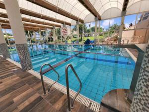 a large swimming pool with blue water in a building at lasuita- exclusive suites cesarea- sea view suite in Caesarea