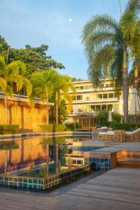 un resort con piscina, palme e un edificio di Selina Serenity Rawai Phuket a Rawai Beach