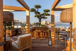a patio with a table and chairs and a view of the ocean at Hotel L'Acquale in Calvi