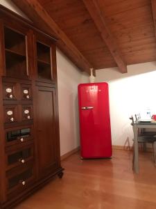 um frigorífico vermelho num quarto com uma mesa em La casetta di San siro em Milão