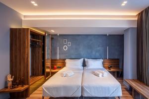 um quarto com uma cama grande e 2 almofadas brancas em Katouni25 Luxury Suites em Tessalônica
