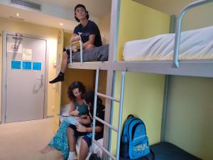 eine Gruppe von Personen, die in einem Etagenbett sitzen in der Unterkunft Twentytu Hostel Barcelona in Barcelona