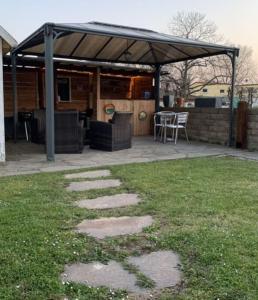 un patio con un pabellón, una mesa y sillas en Rustikale Wohnung mit Garten, en Allensbach