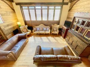 an overhead view of a living room with a couch and chairs at The Timber Barn South Downs West Sussex Sleeps 18 in Hardham
