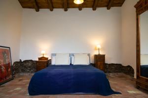 a bedroom with a blue bed with two night stands at La Cantina Villa di campagna in Acireale