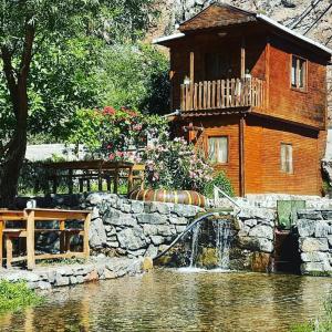 una casa con una fuente de agua frente a un edificio en Kapuzbaşı Şelalesi Baştürk dinlenme tesisleri en Büyükçakır