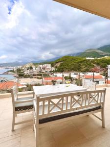 a white table and chairs on a balcony with a view of the ocean at Varja 2 Apartment in Sveti Stefan