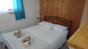 a bedroom with a bed with two slippers on it at Ugodna atmosfera privatnosti, more u blizini. in Vela Luka
