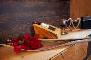 uma mesa com uma garrafa de vinho e rosas vermelhas em Ferienwohnung Bergzauber 1 mit MeineCardPlus em Willingen