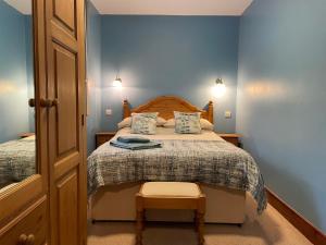 a small bedroom with a bed with blue walls at Milecastle Inn on Hadrian's Wall near Haltwhistle in Haltwhistle