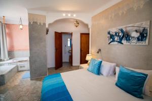 a bedroom with a bed with blue and white pillows at Dar Liouba Hotel in Essaouira