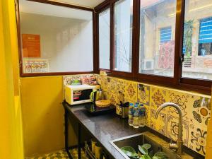cocina con fregadero y microondas en Wooden House 38 Hang Cot - 5' to HoanKiem Lake & Al Noor Mosque, en Hanói