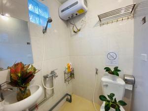 y baño con aseo blanco y lavamanos. en Wooden House 38 Hang Cot - 5' to HoanKiem Lake & Al Noor Mosque, en Hanói