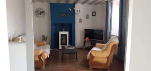 a living room with two couches and a tv at Maison pittoresque et cozy in Bonnat