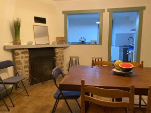 ein Esszimmer mit einem Tisch und einem Kamin in der Unterkunft Maison pittoresque et cozy in Bonnat