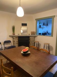 a dining room table with a bowl of watermelon on it at Maison pittoresque et cozy in Bonnat