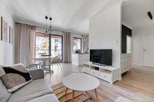 a living room with a couch and a tv and a table at Grand Apartments - Brabank Apartments in Gdańsk