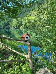 une maison ornithologique sur une clôture à côté d'un étang dans l'établissement Apartment Nura, à Bihać