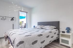 - une chambre blanche avec un lit et une fenêtre dans l'établissement La Villa d'Ezer - Maison contemporaine 4-6 pers, à Loctudy