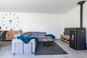 ein Wohnzimmer mit einem Sofa und einem TV in der Unterkunft La Villa d'Ezer - Maison contemporaine 4-6 pers in Loctudy