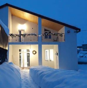 una casa con la neve per terra davanti di Chalet Pkhelshe a Kazbegi