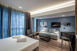 um quarto de hotel com uma cama e uma sala de estar em Katouni25 Luxury Suites em Tessalônica