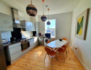 una cocina con mesa y sillas. en Sunny Apartment with a 10 minute walk to the Sea., en Kent