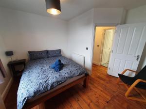 Un dormitorio con una cama con un animal de peluche azul encima. en Sunny Apartment with a 10 minute walk to the Sea., en Kent