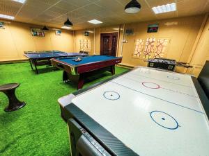 two pool tables in a room with green carpet at AlZaeem Resort & Hotels in Barka