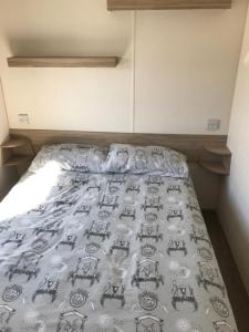 uma cama num quarto com uma colcha em TSCaravan, Haven, Golden Sands em Mablethorpe