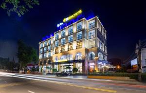un edificio iluminado en una calle de la ciudad por la noche en Da Lat Prince Hotel, en Da Lat