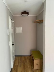 um pequeno quarto com um banco verde e uma porta em Motel Q - das kleine Stadthotel em Dingolfing