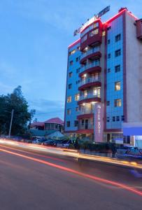 a tall building with cars parked in front of it at Eton Hotel in Thika