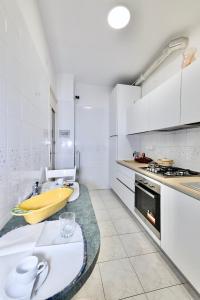 une cuisine avec des placards blancs et un comptoir dans l'établissement Sanremo Dream - Casa di Pietro, à Sanremo
