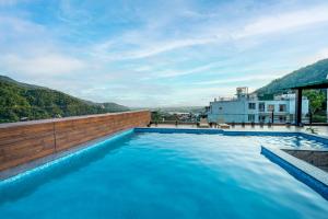 a swimming pool on the roof of a building at Hotel Divine Lakshmi Ganga in Rishīkesh
