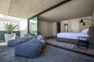 a bedroom with a bed and couches in a room at Villa Pietra - Camps Bay in Cape Town