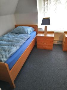 ヴェスターラントにあるGrenzhof-Fischerwohnungのベッドルーム1室(ベッド1台、ドレッサー、ランプ付)