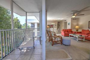 a living room with a balcony with a red couch at Island Beach Club #P1A in Sanibel